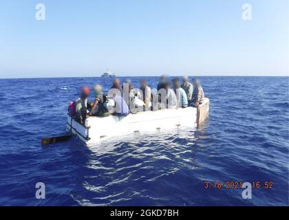 Dix-sept migrants cubains sont assis à bord d'un navire rustique à environ 54 milles au sud de Key West, Floride, le 18 mars 2021. L'équipage du Cutter Charles Sexton de la Garde côtière a interdicté le navire rustique et rapatrié les 17 migrants à Cuba. (Photo de la Garde côtière) Banque D'Images