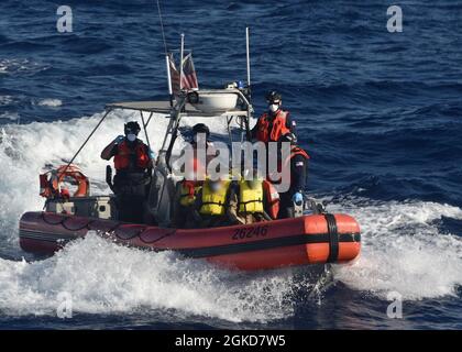 Un Cutter de la Garde côtière Charles Sexton équipe de petit bateau voyage avec 17 migrants cubains interdiqués à bord d'environ 54 miles au sud de Key West, Floride, le 18 mars 2021. L'équipage de Charles Sexton a interdicté le navire rustique et rapatrié les 17 migrants à Cuba. (Photo de la Garde côtière) Banque D'Images