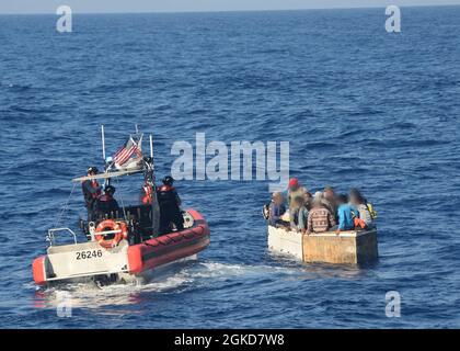 Un Cutter de la Garde côtière Charles Sexton équipage de petit bateau interdit 17 migrants cubains à bord d'un navire rustique à environ 54 miles au sud de Key West, Floride, le 18 mars 2021. L'équipage de Charles Sexton a interdicté le navire rustique et rapatrié les 17 migrants à Cuba. (Photo de la Garde côtière) Banque D'Images