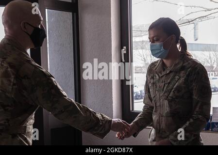 US Air Force Brig. Général Josh Olson, 86e commandant de l'escadre du transport aérien, à gauche, coins Tech. Sgt. Samantha Williams, 86e officier responsable de la normalisation et de l'évaluation du Escadron des forces de sécurité, après l'avoir reconnu comme le transporteur aérien de la semaine à la base aérienne de Ramstein, en Allemagne, le 18 mars 2021. Williams a été reconnu pour avoir renforcé le concept Airman qui forme les membres de la Force aérienne d'aujourd'hui. Banque D'Images