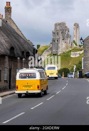 CHÂTEAU DE CORFE, ROYAUME-UNI - 18 août 2021 : deux campans VW traversant le village avec le château de Corfe en arrière-plan Banque D'Images