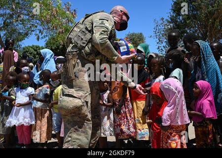 Un soldat Bayonet de la Force opérationnelle affecté à la Compagnie Alpha, 2e Bataillon, 135e Régiment d'infanterie, remet des bonbons à Lamu (Kenya), le 20 mars 2021. Les soldats ont recueilli des dons de leurs proches aux États-Unis du 2020 novembre au 2021 mars dans le cadre d'un soutien humanitaire à la région. Banque D'Images