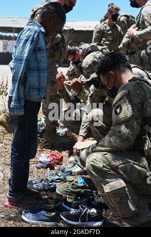 Un garçon du village de Magogoni attend pour essayer des chaussures à Lamu, Kenya, le 20 mars 2021. Les soldats de la Force opérationnelle Bayonet affectés à la Compagnie Alpha de l'armée américaine, 2e Bataillon, 135e Régiment d'infanterie, ont recueilli des dons de proches aux États-Unis du 2020 novembre au 2021 mars dans le cadre d'un soutien humanitaire à la région. Banque D'Images