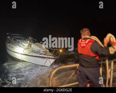 Un membre d'équipage de la station de la Garde côtière Key West se prépare à lancer une ligne de remorquage vers le navire à voile handicapé Mystic, à environ 60 milles au nord-ouest de Marathon, Floride, le 21 mars 2021. Les unités aériennes et maritimes de la Garde côtière ont répondu à une alerte de balise de localisation personnelle du navire et l'ont remorqué jusqu'à la sécurité. (Photo de la Garde côtière) Banque D'Images