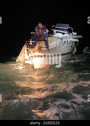 Station de la Garde côtière les membres d'équipage de Key West préparent le bateau à voile pour personnes handicapées, Mystic, pour le remorquage à environ 60 milles au nord-ouest de Marathon, Floride, le 21 mars 2021. Les unités aériennes et maritimes de la Garde côtière ont répondu à une alerte de balise de localisation personnelle du navire et l'ont remorqué jusqu'à la sécurité. (Photo de la Garde côtière) Banque D'Images