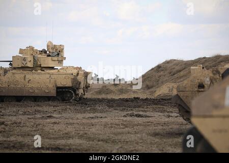 AIRE D'ENTRAÎNEMENT SMARDAN, Roumanie— soldats du 2e Bataillon, 5e Régiment de cavalerie, 1re équipe de combat de la brigade blindée, 1re division de cavalerie manœuvre M2A3 Bradley véhicules de combat pour s'aligner avec les chars de bataille principaux roumains TR-85 lors de l'exercice de force conjointe Justice Eagle ici le 23 mars. L'exercice comprenait la participation des États-Unis, de la Pologne et de la Roumanie. Les événements d’entraînement Atlantic Resolve comme Justice Eagle renforcent les liens entre les alliés de l’OTAN et font la démonstration de forces cohésives, prêtes et capables. Banque D'Images