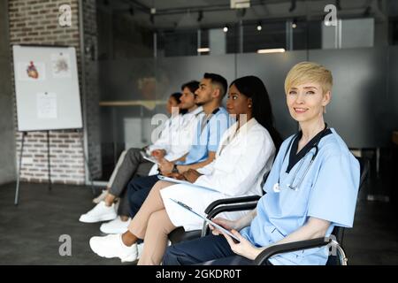 Femme blonde d'âge moyen médecin assistant à une conférence médicale Banque D'Images