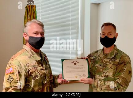 Le capitaine Jeffery Benton, directeur adjoint des affaires civiles, 1er Commandement du soutien du théâtre, reçoit la Médaille du service méritoire par le colonel Joseph R. Kurz, chef de cabinet, 1er TSC, à fort KNOX, Kentucky, 24 mars 2021. Benton a été reconnu pour son travail au-dessus de son niveau de responsabilité et pour la création de procédures opérationnelles standard couvrant les affaires civiles pour le 1er TSC dans la zone de responsabilité du Commandement central. Banque D'Images