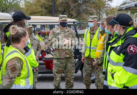 Le général de division de l'armée américaine Pablo Estrada, commandant de la Force opérationnelle 46 (au centre), parle avec le personnel médical de la Force aérienne américaine avec le 5e groupe médical de la base aérienne de Minot, Dakota du Nord, Et les techniciens médicaux d'urgence (EMT) du corps d'urgence du comté de Harris au NRG Community vaccination Center (CVC) à Houston, le 24 mars 2021. Estrada a remercié les aviateurs de la US Air Force et les EMT du comté de Harris pour leur service et leur contribution au CVC, ainsi qu'aux efforts de vaccination de la COVID-19. Le Commandement du Nord des États-Unis, par l'intermédiaire de l'Armée du Nord des États-Unis, demeure déterminé à fournir un service D flexible et continu Banque D'Images