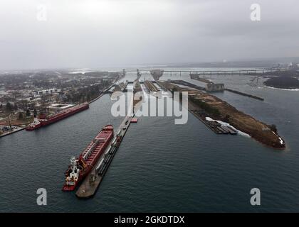 Deux navires et leurs péniches se préparent à traverser les écluses de Soo en route vers le lac supérieur le 24 mars 2021, le premier jour de la saison. Les écluses de Soo, exploitées par le corps des ingénieurs de l'Armée de terre et situées à Sault Ste Marie, Michigan, assurer un transport sûr et économique des matières premières et autres marchandises entre le lac supérieur et les centres industriels le long des Grands Lacs inférieurs, comme Detroit, Cleveland et la région de Chicago. Banque D'Images