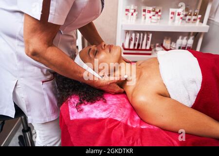 Un cosmétologue compétent fait un massage du cou et de l'épaule Banque D'Images