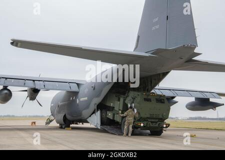 Les maîtres de charge affectés à l'escadre des opérations spéciales 352d chargent un système de fusée d'artillerie à haute mobilité (HImars) sur un MC-130J Commando II à la RAF Mildenhall le 24 mars 2021. Les capacités spéciales de l’opération améliorent l’exécution des missions d’insertion aérienne rapide de HImars, étendent la portée des capacités de frappe de précision à longue portée et permettent la force conjointe. Banque D'Images