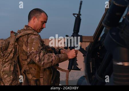 Un membre du service de la Force aérienne américaine affecté au 303e Escadron de sauvetage expéditionnaire charge son équipement avant un exercice au Camp Simba, au Kenya, le 24 mars 2021. Le 303e NQE effectue des exercices de formation de jour comme de nuit pour assurer l'évacuation des blessés, un soutien aérien rapproché et le rétablissement du personnel. Banque D'Images