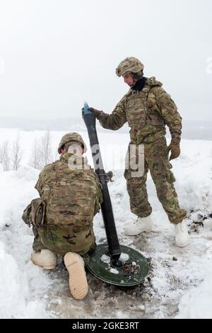 Le mortaren de l'armée affecté au quartier général et à la Compagnie du quartier général, 3e Bataillon, 509e Régiment d'infanterie de parachutisme, 4e équipe de combat de la Brigade d'infanterie (Airborne), 25e division d'infanterie, armée américaine Alaska, exploite le système de mortier M252 de 81 mm pendant l'entraînement en direct à la base interarmées Elmendorf-Richardson, Alaska, le 25 mars 2021. Les soldats ont perfectionné leur équipage a servi des techniques d'armes en effectuant des missions de feu en hiver. Banque D'Images