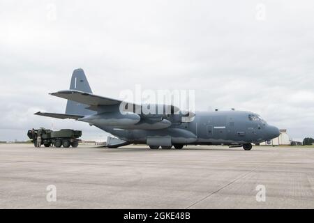 Les chargés de charge affectés à la 352d escadre des opérations spéciales et les marines de la 24e unité expéditionnaire maritime se préparent à charger un système de fusée d'artillerie à haute mobilité (HImars) sur un MC-130J Commando II prêt pour le décollage à la RAF Mildenhall le 26 mars 2021. Les capacités SOF améliorent l'exécution des missions d'insertion aérienne rapide de HImars, étendent la portée des capacités de frappe de précision à longue portée et permettent la force conjointe. Banque D'Images