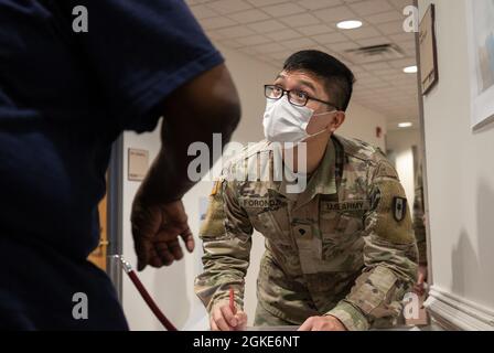 SPC de l'armée américaine. Aian Foronda, une Ewa Beach, Hawaii, native et infirmière affectée au 531e Centre hospitalier, parle à un membre de la communauté à la First Baptist Church of Lincoln Gardens COVID-19 Community vaccine Centre de Somerset, New Jersey, gérée par l'État et appuyée par le gouvernement fédéral, le 26 mars 2021. Ce centre vaccine actuellement les membres de la communauté en raison de leur deuxième dose du vaccin COVID-19. Le Commandement du Nord des États-Unis, par l'intermédiaire de l'Armée du Nord des États-Unis, demeure déterminé à fournir un soutien continu et souple du ministère de la Défense à l'Agence fédérale de gestion des urgences dans le cadre de l'ensemble du gouvernement Banque D'Images