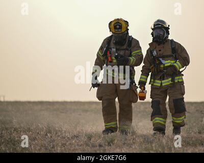 Deux pompiers de l'armée de l'air américaine affectés à la 386e Escadre expéditionnaire de l'air participent à un exercice d'accident d'avion à la base aérienne Ali Al Salem, Koweït, le 26 mars 2021. Ces aviateurs ont joué un rôle important dans l'exercice en assurant la sécurité de la scène de l'accident, en fournissant des soins médicaux et en mettant en sécurité les survivants. Banque D'Images