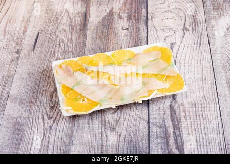 Salade avec des tranches de courge musquée fumée et des tranches d'orange avec une sauce au sirop vert sur le dessus Banque D'Images