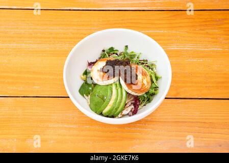 salade de fromage de chèvre avec avocat, laitue, arugula et oignon caramélisé dans un bol blanc Banque D'Images