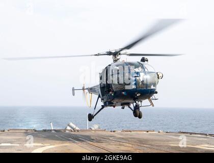 OCÉAN INDIEN (28 mars 2021) un hélicoptère Chetak de la Marine indienne se lève du pont de vol du croiseur à missiles guidés de classe Ticonderoga USS Bunker Hill (CG 52) lors d'un exercice maritime de la force conjointe le 28 mars 2021. Bunker Hill, qui fait partie du groupe de grève des transporteurs Theodore Roosevelt, est en cours de déploiement prévu dans la zone d'exploitation de la 7e flotte américaine. En tant que plus grande flotte déployée à l’avant de la Marine américaine, la 7e flotte opère et interagit régulièrement avec 35 nations maritimes tout en effectuant des missions pour préserver et protéger une région Indo-Pacifique libre et ouverte. Banque D'Images