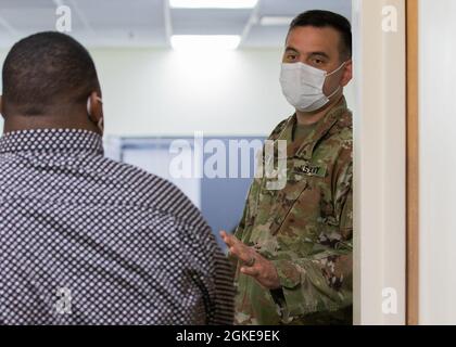 Sergent de l'armée américaine Raymond Liens, natif de Miami, et médaillé de combat affecté à la clinique de santé de l'Armée de Kenner, accueille des membres de la communauté au centre de vaccination communautaire COVID-19 géré par l'État et soutenu par le gouvernement fédéral, qui opère à partir du Centre de louange et de culte de Jéhovah-Jireh, Newark, New Jersey, le 28 mars 2021. Les employés de l'État du New Jersey, le personnel de l'Agence fédérale de gestion des urgences et les membres des services sont arrivés au centre plusieurs heures avant son ouverture afin d'assurer un processus sans heurts pour les membres de la communauté. Le Commandement du Nord des États-Unis, par l'intermédiaire de l'Armée du Nord des États-Unis, demeure déterminé à fournir le contuin Banque D'Images