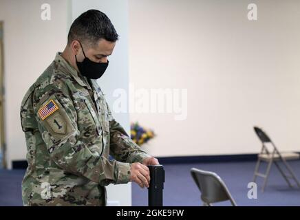 Sergent de l'armée américaine Joel Cruz, originaire de Miami, et médaillé de combat affecté à l'hôpital communautaire de l'armée de Blanchfield, aide à installer la zone d'observation au centre de vaccination communautaire COVID-19 géré par l'État et financé par le gouvernement fédéral, qui opère à partir du Centre de louange et de culte de Jéhovah-Jireh, Newark (New Jersey), le 28 mars 2021. Les employés de l'État du New Jersey, le personnel de l'Agence fédérale de gestion des urgences et les membres des services sont arrivés au centre plusieurs heures avant son ouverture afin d'assurer un processus sans heurts pour les membres de la communauté. Le Commandement du Nord des États-Unis, par l'intermédiaire de l'Armée du Nord des États-Unis, demeure un comité Banque D'Images