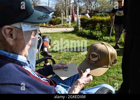 21033--N-RB391-362 (le 30 mars 2021) RALEIGH, NC - Leon Howell, un vétéran de la Seconde Guerre mondiale, lui admire une casquette de commande présentée par un technicien en électronique, énergie nucléaire (ETN) Petty Officer de 1re classe Anthony M. Augustine, un marin de la marine américaine affecté à Navy Talent acquisition Group (NTAG) Carolina, lors d'une célébration d'anniversaire de « passage ». Howell a servi à bord de l'USS Vega (AK-17) lors de l'attaque infâme contre Pearl Harber (DEC. 7, 1941). Son navire a gagné quatre étoiles de bataille pour la Seconde Guerre mondiale. Howell a 99 ans le 31 mars. Banque D'Images
