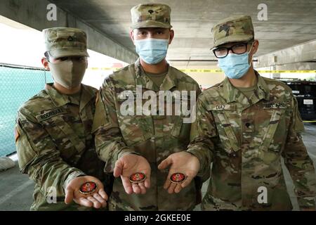 Soldats de la Garde nationale de l'armée PFC. Jose Luis Rodriguez, analyste de renseignements à la 40e Division d'infanterie, SPC. Moreno Mason, musicien de la 40e Division d'infanterie, et de la CPS. Jack Diaz, mécanicien de véhicules à roues de la 40e Division d'infanterie, montre les pièces de monnaie qu'ils ont reçues de l'honorable Mario A. Guerra, aide civile au secrétaire de l'Armée, à l'Université d'État de Californie à Los Angeles, le 30 mars 2021. Le site est exploité par plusieurs organismes fédéraux et d'État, dont la Garde nationale de Californie. Banque D'Images