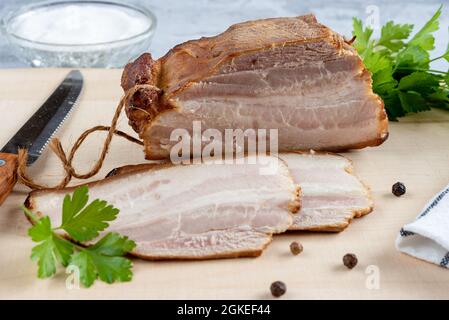 Morceaux de bacon fumé aromatique sur une planche à découper Banque D'Images