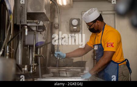210330-N-XR893-1021 PORTSMOUTH, Virginie (30 mars 2021) le technicien en chef des systèmes d'information Nathan Kerley, d'Austin, Texas, lave un pot dans le puits profond de l'une des huit chaberies à bord du porte-avions USS Harry S. Truman (CVN 75) de la classe Nimitz dans le cadre d'une célébration d'anniversaire d'une semaine des officiers en chef Petty. Truman est actuellement dans le chantier naval de Norfolk pour sa période de disponibilité incrémentale des transporteurs étendus (ECIA). Banque D'Images