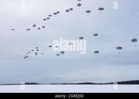 Les parachutistes de l'armée affectés au 1er Bataillon, 501e Régiment d'infanterie de parachutisme, 4e équipe de combat de la Brigade d'infanterie (Airborne), 25e division d'infanterie, armée américaine Alaska, descendent au-dessus de la zone de chute de Malemute après avoir sauté d'un US Air Force C-130J Super Hercules lors d'une simulation d'assaut de parachute à entrée forcée à la base interarmées Elmendorf-Richardson, Alaska, Alaska, 31 mars 2021. Des aviateurs de la 374e Escadre de transport aérien de la base aérienne de Yokota, au Japon, ont fourni des équipements aériens pour l'opération d'entraînement. Les soldats font partie de la seule brigade aérienne de l’Armée de terre dans le Pacifique qui a la capacité de se déployer rapidement dans le monde entier et Banque D'Images