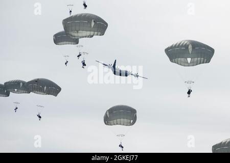 Les parachutistes de l'armée affectés au 1er Bataillon, 501e Régiment d'infanterie de parachutisme, 4e équipe de combat de la Brigade d'infanterie (Airborne), 25e division d'infanterie, armée américaine Alaska, descendent au-dessus de la zone de chute de Malemute après avoir sauté d'un US Air Force C-130J Super Hercules lors d'une simulation d'assaut de parachute à entrée forcée à la base interarmées Elmendorf-Richardson, Alaska, Alaska, 31 mars 2021. Des aviateurs de la 374e Escadre de transport aérien de la base aérienne de Yokota, au Japon, ont fourni des équipements aériens pour l'opération d'entraînement. Les soldats font partie de la seule brigade aérienne de l’Armée de terre dans le Pacifique qui a la capacité de se déployer rapidement dans le monde entier et Banque D'Images