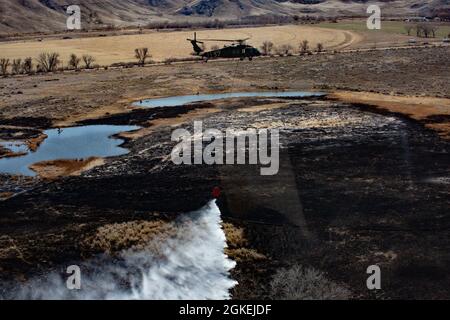 Les membres de la Garde nationale de l'Utah 2-211e Bataillon de l'aviation de soutien général volant dans deux HÉLICOPTÈRES UH-60 Black Hawk larlent des seaux d'eau sur le feu du complexe East Myton dans le comté de Duchesne le 31 mars 2021. Banque D'Images