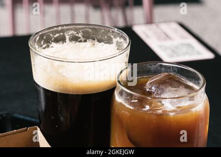 Deux verres de café de préparation froide, l'un avec du nitro et l'autre avec du lait. Banque D'Images