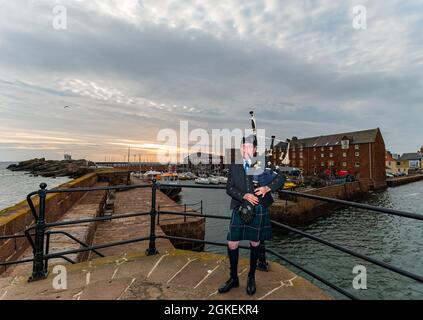 Piper joue des cornemuses à l'aube pour commémorer la St Valery Day (soldats écossais capturés dans la deuxième Guerre mondiale), port de North Berwick, East Lothian, Écosse, Royaume-Uni Banque D'Images