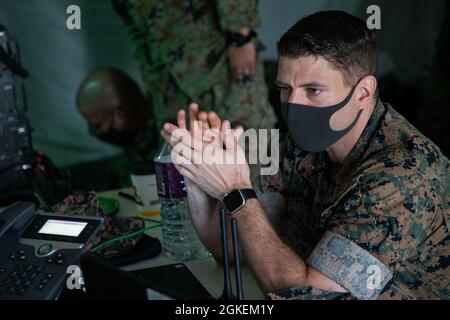 L'Adjudant-chef du corps des Marines des États-Unis, 2 Johnathon Patrick, ingénieur en systèmes de données au sein de l'Escadron des communications de la Marine Wing (MWCS) 18, observe les Marines qui travaillent avec les membres de la 15e Brigade de signalisation japonaise lors d'un exercice de formation conjoint sur les communications radio au Camp Foster, Okinawa, Japon, le 31 mars 2021. Le MWCS-18 a tenu un exercice de communication bilatéral afin d'améliorer les capacités et les relations diplomatiques avec la Force d'autodéfense terrestre du Japon. Banque D'Images