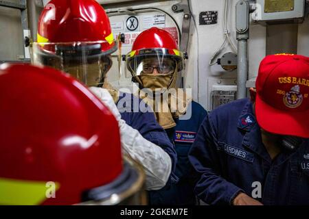 MER DES PHILIPPINES (mars 31, 2021) – des marins à bord du destroyer à missiles guidés USS Barry (DDG 52) de classe Arleigh-Burke effectuent des exercices de lutte contre les incendies pendant les opérations courantes en cours. Barry est affecté à la Force opérationnelle 71/escadrille de Destroyer (DESRON 15), la plus importante force de surface déployée par la Marine et la plus importante force de surface de la 7e flotte américaine. Banque D'Images