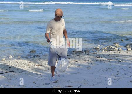 DIEGO GARCIA, territoire britannique de l'océan Indien (1er avril 2021) – le maître de Yeoman Adam Freeze, affecté à l'installation de soutien de la marine américaine Diego Garcia, ramasse les déchets lors d'un nettoyage de plage à bord de l'installation de soutien de la marine américaine Diego Garcia le 1er avril 2021. NSF Diego Garcia fournit un soutien logistique, de service, récréatif et administratif aux forces américaines et alliées déployées vers l'océan Indien et le golfe Arabique. Banque D'Images