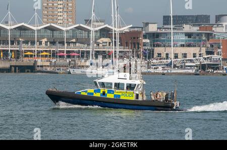 Portsmouth, Angleterre, Royaume-Uni. 2021. Patrouilleur de police passant devant le complexe Gunwharf Quays à Portsmouth Harbour, Royaume-Uni. Banque D'Images