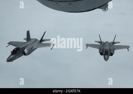 Deux avions F-35B Lightning II du corps des Marines des États-Unis provenant de l'escadron d'attaque de chasseurs marins 242 du MCAS Iwakuni, au Japon, s'alignent sur une formation de deux navires après avoir ravitaillé pendant l'exercice Westpac Rumrunner, le 2 avril 2021. La Stratégie de défense nationale (PDN) nous demande d'être plus létale, d'améliorer les relations avec les alliés et les partenaires et d'encourager la réforme institutionnelle; la 18e Escadre appuie cette PDN en élaborant et en poursuivant de nouveaux exercices d'entraînement comme Westpac Rumrunner. Banque D'Images