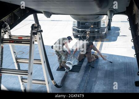 Deux membres du 380e Escadron de maintenance d'aéronefs expéditionnaires fixent une rague à un camion lors de l'entretien de routine à la base aérienne d'Al Dhafra, aux Émirats arabes Unis, le 6 avril 2021. Un système de ravitaillement par tuyau et par voie droite sur un KC-10 subit un entretien régulier de 12 semaines pour s'assurer qu'il est capable de ravitailler une grande variété d'avions militaires américains et alliés dans la même mission. Banque D'Images