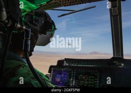 Le 1er lieutenant Eric L. Taylor du corps des Marines des États-Unis, pilote d'hélicoptère UH-1Y Venom avec l'escadron d'attaque de la lumière marine (HMLA) 269, survole le Marine corps Air-Ground combat Centre, Twentynine Palms, Californie, le 6 avril 2021. La HMLA-269 et d'autres escadrons affectés au Groupe aérien maritime (MAM) 29 forment à intégrer et à soutenir diverses unités terrestres marines dans le cadre de l'exercice de formation sur le niveau de service (ESLTE) 3-21. SLTE est une série d'exercices conçus pour préparer les Marines à des opérations dans le monde entier en augmentant leur capacité à opérer et à mener des opérations de combat offensives et défensives. MAG-29 i Banque D'Images