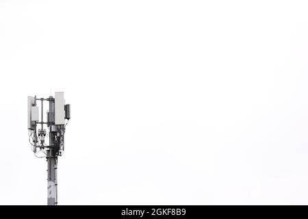 Un mât de communications téléphoniques mobiles, vu avec un ciel blanc clair au-dessus de Belfast, en Irlande du Nord. Banque D'Images