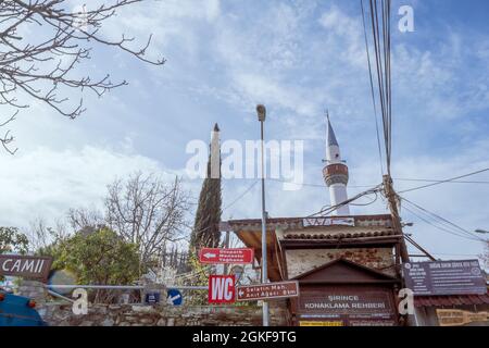 Sirince, Izmir, Turquie - 03.08.2021: entrée du village de Sirince avec des panneaux de signalisation et un minaret d'arbre et de mosquée dans un air clair Banque D'Images