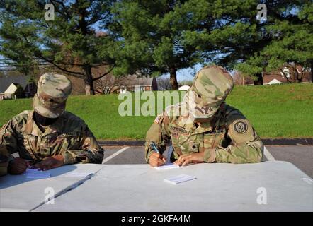 CDT. Taliyah Warden (à gauche) et CDT. Kyla Patterson, tous deux de la 1229e compagnie de transport, 1297e Bataillon de soutien du service de combat, Garde nationale de l'armée du Maryland, tient des dossiers administratifs pour les patients à l'extérieur de l'église presbytérienne coréenne Bethel le 7 avril 2021. Situé à Ellicott City, Maryland, le site était l'un des sites de vaccination assistés par l'un des trois bus mobiles de vaccination grâce à la coordination du Groupe de travail sur l'équité en matière de vaccins. Le MDNG a été activé pour appuyer la réponse COVID-19 du Maryland en fournissant un soutien direct aux services de santé du comté pour les aider Banque D'Images