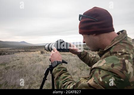 CENTRE D'ENTRAÎNEMENT DE YAKIMA, Washington – Un Beret vert avec 2e Bataillon, 1er Groupe des forces spéciales (Airborne) utilise un appareil photo reflex numérique à objectif unique pour l'entraînement de reconnaissance et de surveillance à long terme au Centre d'entraînement de Yakima, Washington, 7 avril 2021. Cet événement faisait partie d'un exercice d'entraînement de trois jours qui comprenait l'insertion de freefall, la reconnaissance spéciale et l'établissement d'une zone d'atterrissage pour se préparer aux futures missions du monde réel. Banque D'Images