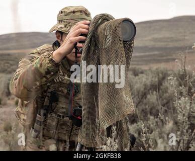 CENTRE D'ENTRAÎNEMENT DE YAKIMA, Washington – Une Béret verte avec 2e Bataillon, 1er Groupe des forces spéciales (Airborne) surveille les positions ennemies pendant l'entraînement de reconnaissance et de surveillance à long terme au Centre d'entraînement de Yakima, Washington, 7 avril 2021. Cet événement faisait partie d'un exercice d'entraînement de trois jours qui comprenait l'insertion de freefall, la pratique de reconnaissance spéciale et l'établissement d'une zone d'atterrissage pour se préparer aux futures missions du monde réel. Banque D'Images