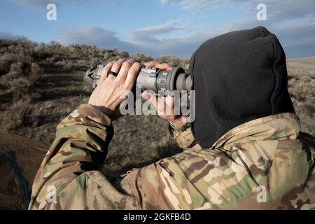 CENTRE D'ENTRAÎNEMENT DE YAKIMA, Washington – Un béret vert du 2e Bataillon, 1er Groupe des forces spéciales (Airborne) utilise une vue monoculaire thermique lors de l'entraînement de reconnaissance et de surveillance à long terme au Centre d'entraînement de Yakima, Washington, 7 avril 2021. Cet événement faisait partie d'un exercice d'entraînement de trois jours qui comprenait l'insertion de freefall, la pratique de reconnaissance spéciale et l'établissement d'une zone d'atterrissage pour se préparer aux futures missions du monde réel. Banque D'Images