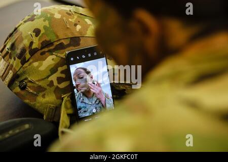 SPC de la Réserve de l'armée américaine. Arianna Hammel, analyste de renseignements au 15e Bataillon des opérations psychologiques, applique de la peinture de camouflage pour préparer une qualification de gamme au cours du premier jour de la compétition du meilleur guerrier du Commandement des affaires civiles et des opérations psychologiques de l'Armée américaine (Airborne) de 2021 à fort Jackson, L.C., 8 avril 2021. Le BWC USACAPOC(A) est un événement annuel qui réunit des concurrents de partout dans USACAPOC(A) pour gagner le titre de « meilleur guerrier ». BWC teste la capacité individuelle des soldats à s’adapter et à surmonter des scénarios difficiles et des événements axés sur la bataille, en testant leur technique Banque D'Images