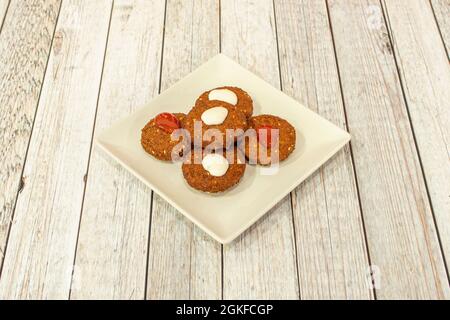 Présentation habituelle d'une portion de falafel avec une sauce blanche et rouge préparée dans un kebab pakistanais Banque D'Images